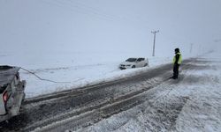 Kar yağışına yakalanan araç yola saplandı