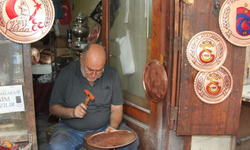 Türkü söyleyerek bakıra şekil veriyor